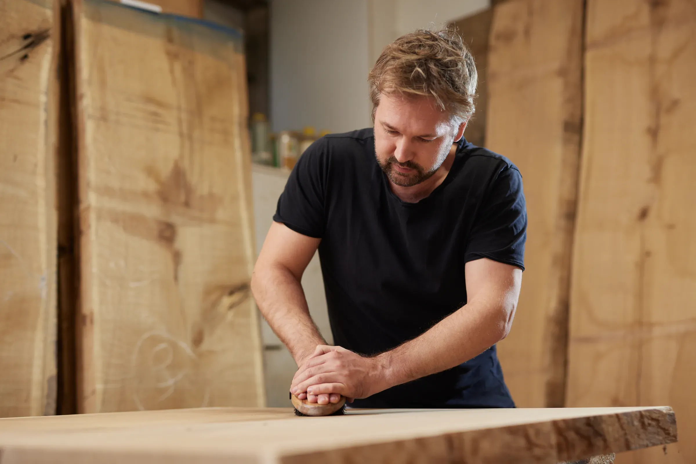 Eine Massivholzplatte wird von Hand gebürstet