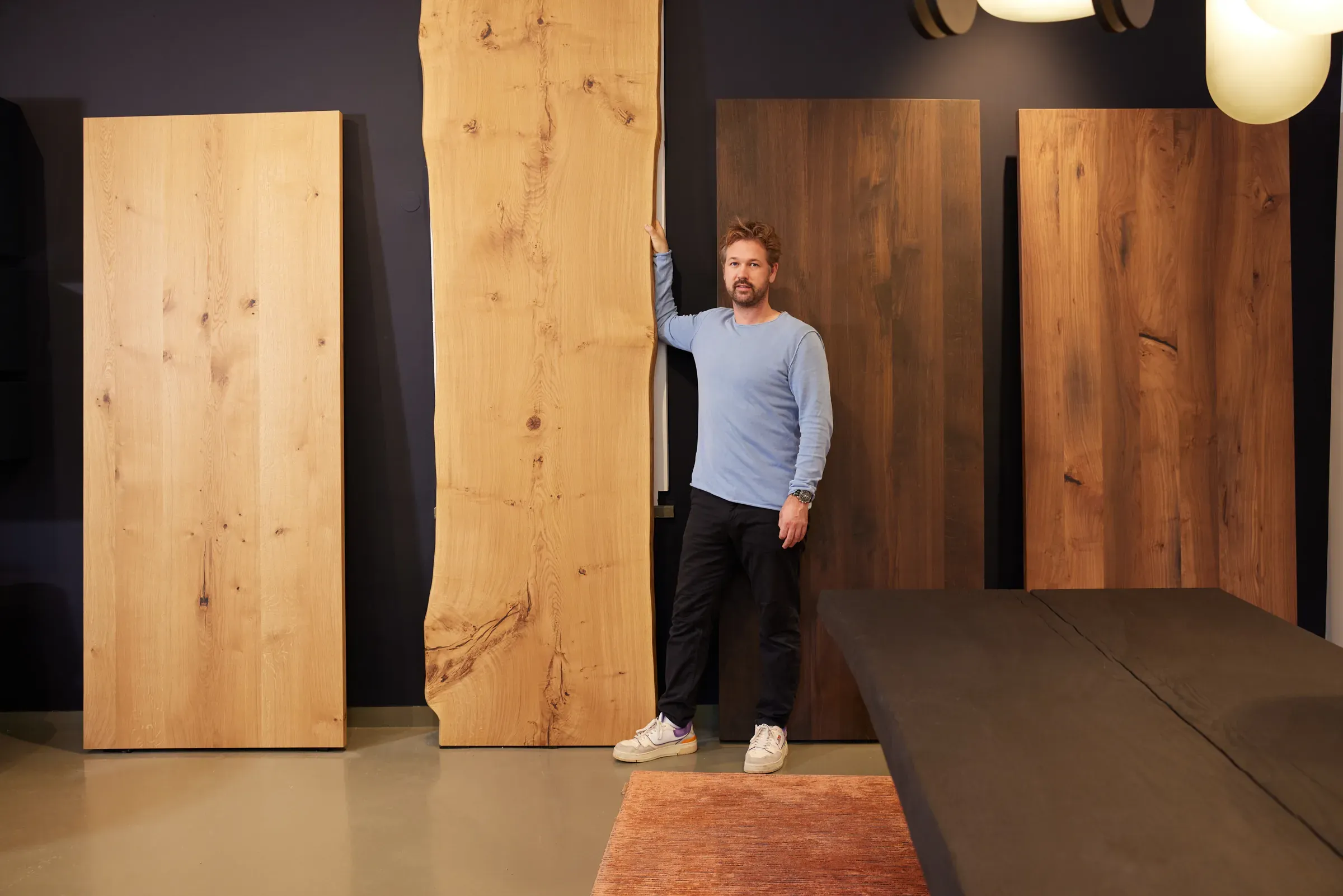 Niels Klün zwischen aufgestellten Tischplatten mit Naturkante