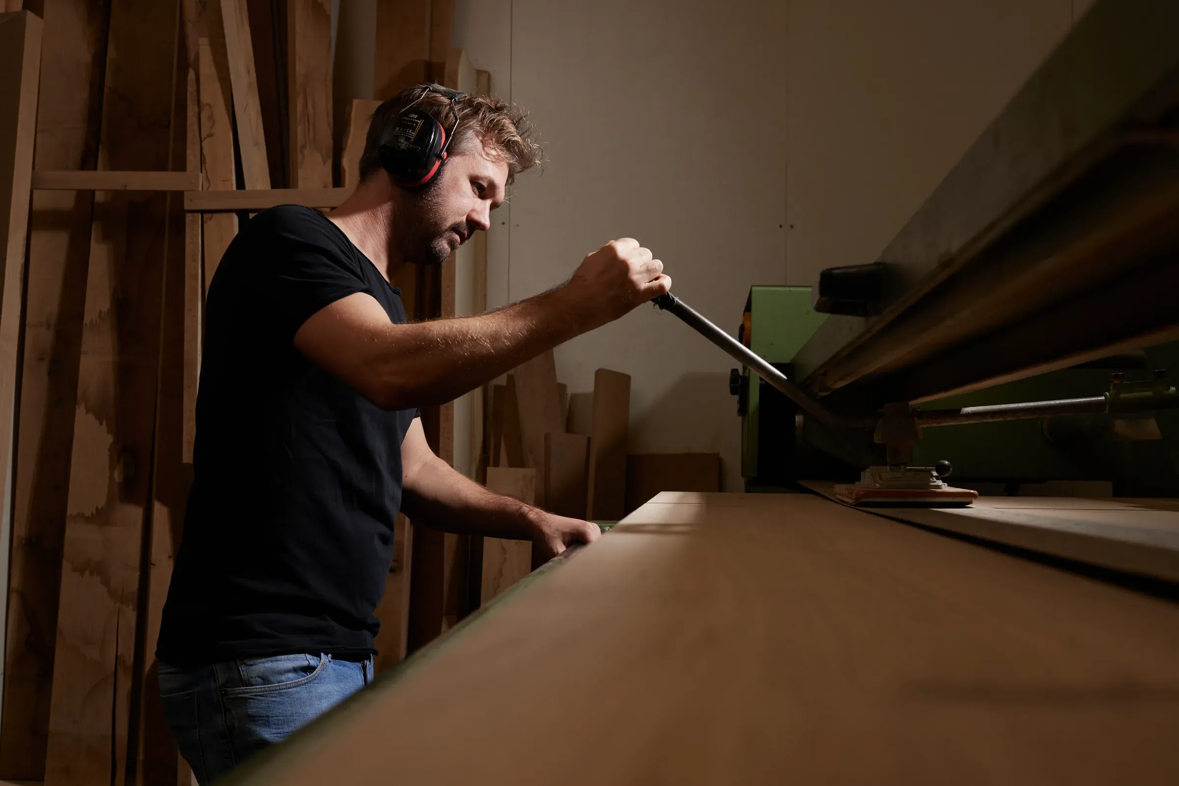 Niels Klün schleift eine Tischplatte an der Maschine