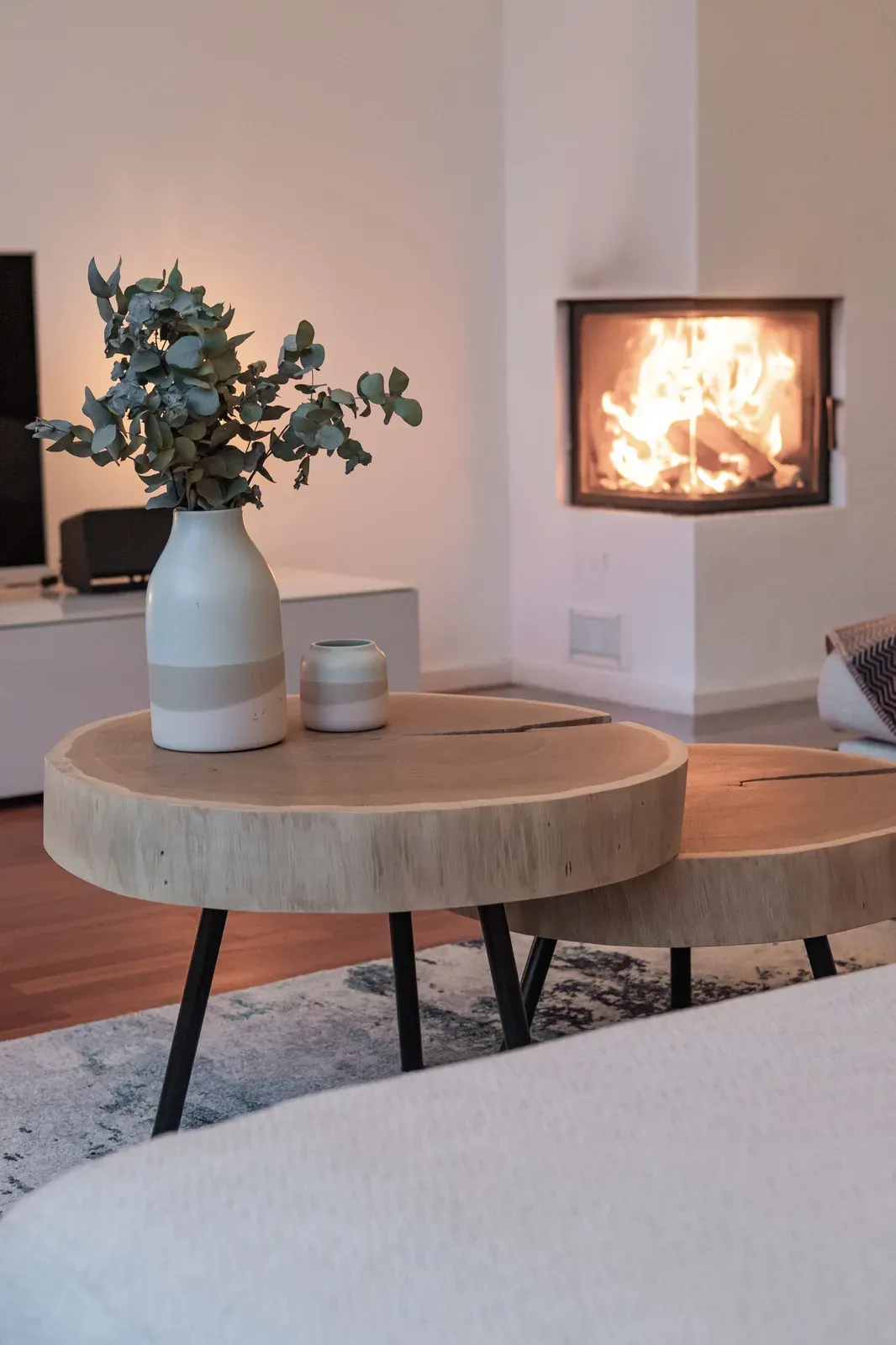 Zweiteiliger Couchtisch aus Eichenscheiben vor einem Kamin
